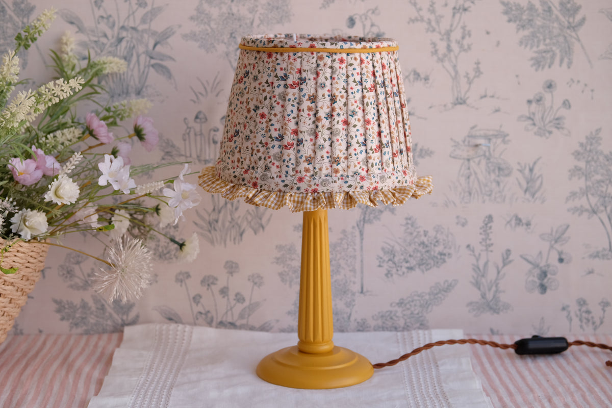 Lamparita con tulipa plisada beige de florecitas y volante mostaza
