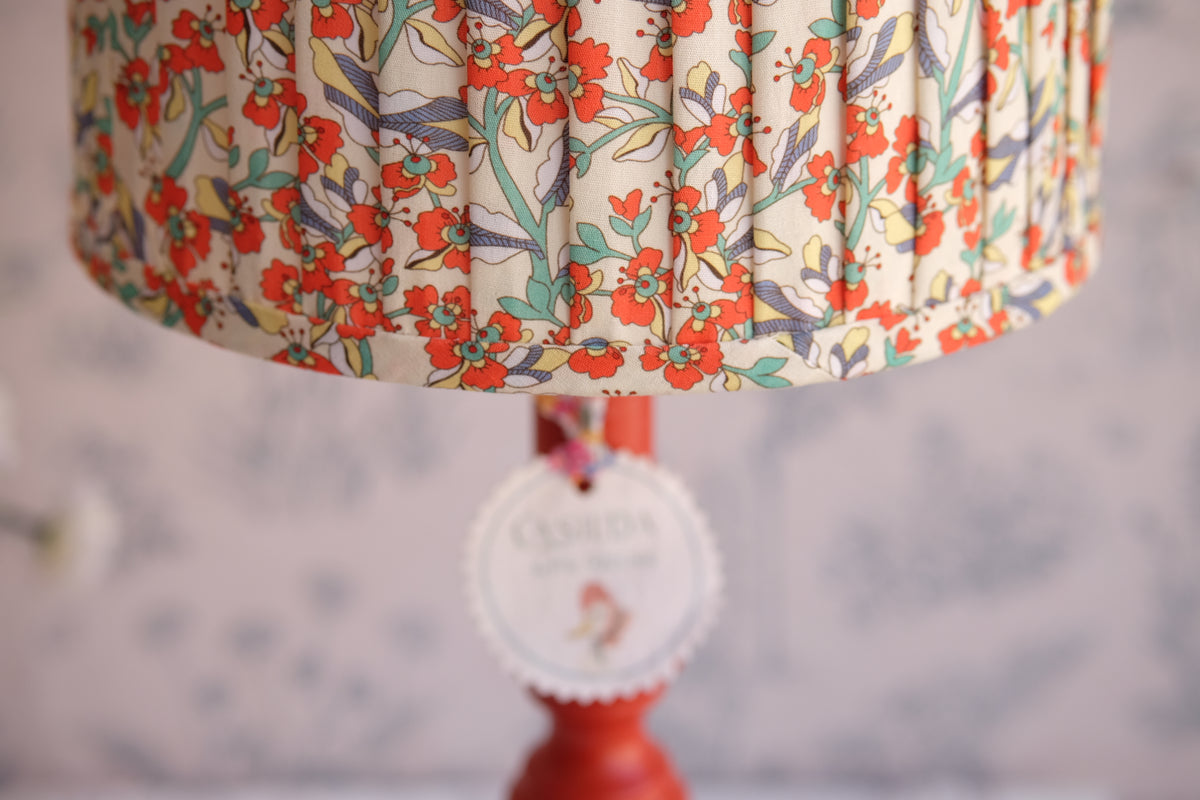 Lámpara roja con tulipa plisada vainilla con flores rojas y azules